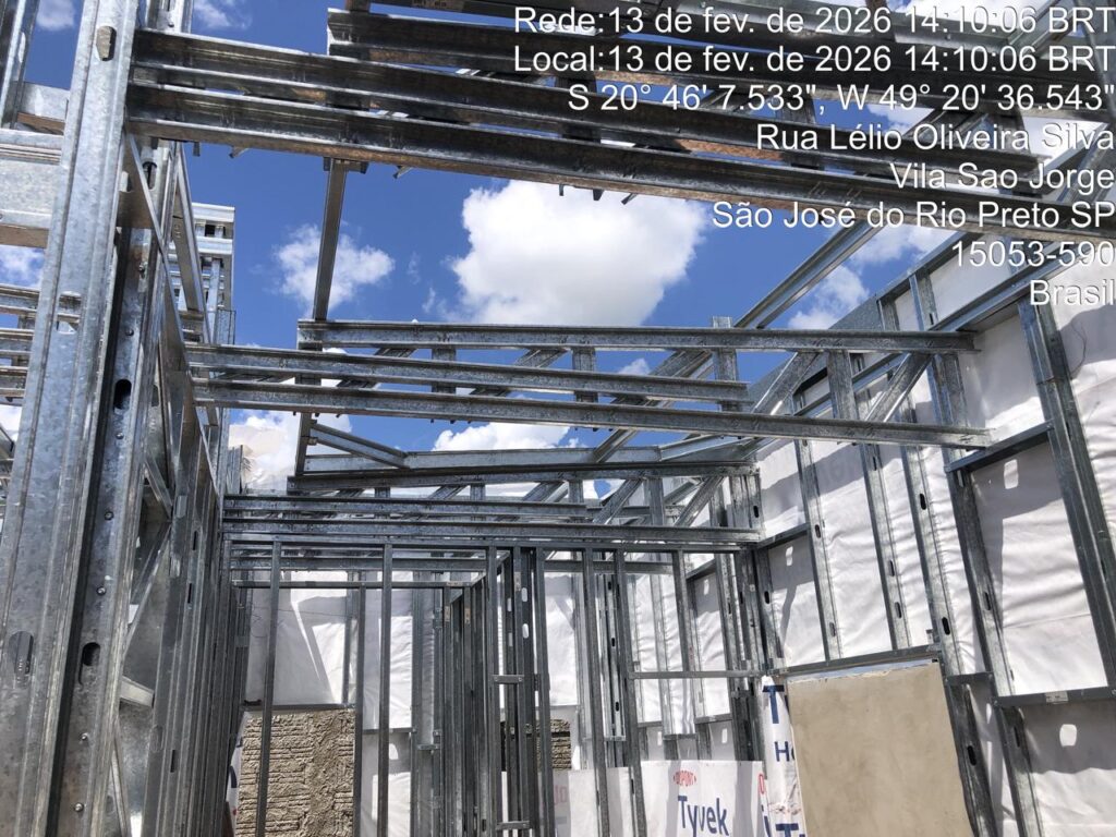 Estrutura de perfis metálicos (steel frame) montada, mostrando o esqueleto em aço galvanizado das paredes e da cobertura em obra da Hanna & Hanna